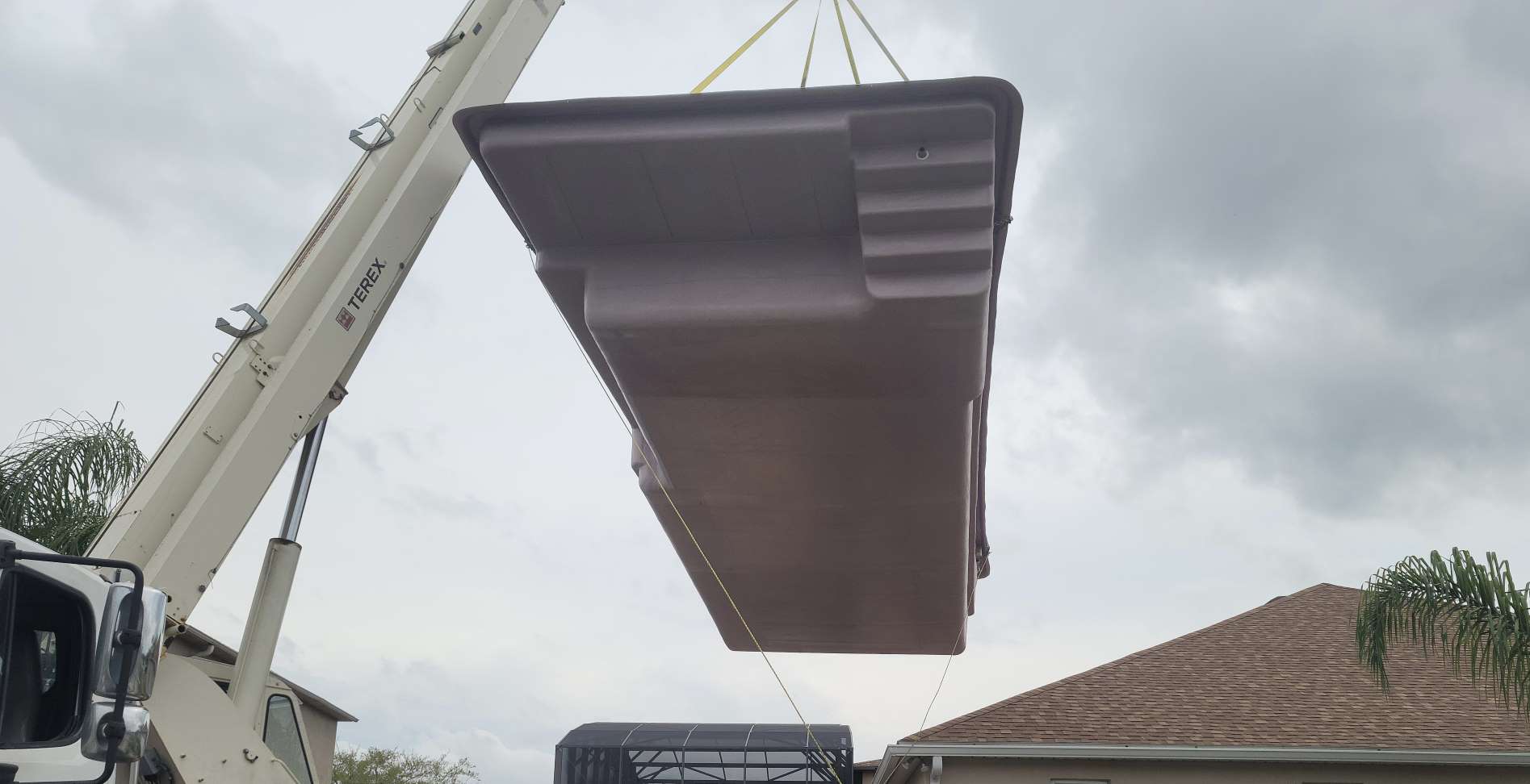 Fiberglass pool shell being delivered during installation