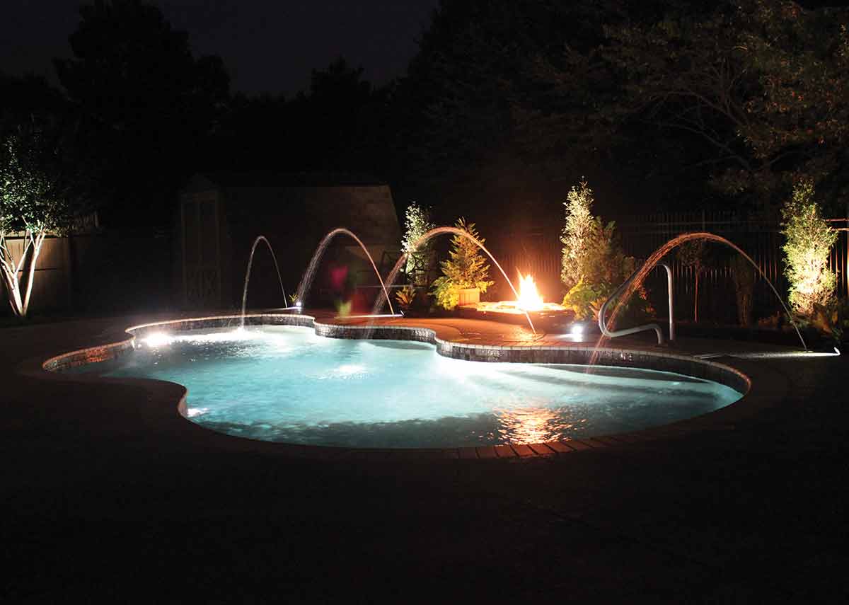 Illuminated backyard swimming pool beneath a Florida evening sky