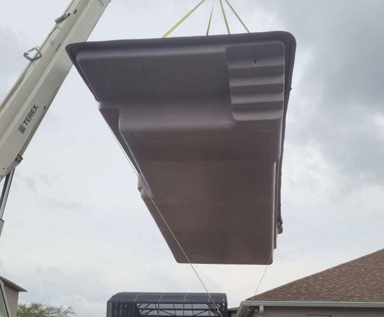 Fiberglass pool shell being delivered during installation